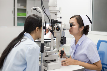 Female doctor using machine for check patient eye. People with medical concept.