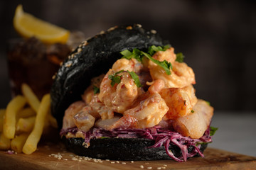 Black burger with fish and shrimps. Fishburger with prawns