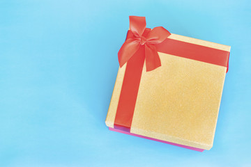 Beautiful gift box with a ribbon on the blue background.