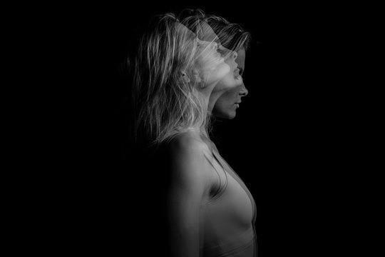 Beautiful fuzzy drama mystical mysterious ambiguous original conceptual profile side portrait of young blonde woman on a black background. Black and white photo. triple exposure.