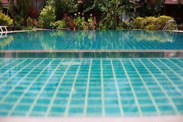 Swimming pool in tropical garden with bamboo bungalow - paradise for tourists.