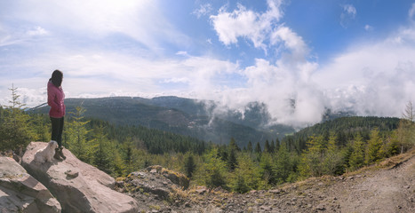 Girl with dog enjoying a mountain view