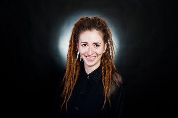 Fototapeta premium Studio shoot of girl in black with dreads at black background with nimbus.