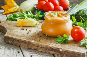 Squash zucchini paste in a glass jar surrounded by the ingredients