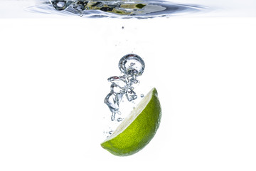 Fototapeta na wymiar Fresh lime fruit water splash with bubbles