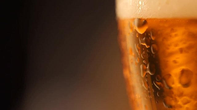Detail of beer glass with bubbles. Close up beer background, slow motion.