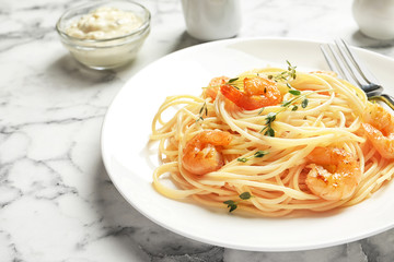 Plate with spaghetti and shrimps on table