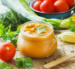 Squash zucchini paste in a glass jar surrounded by the ingredients