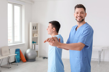 Fototapeta premium Physiotherapist working with male patient in clinic
