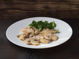  mushrooms on white plate, food on dark background