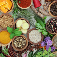 Spice and herb selection  in wooden bowls and loose forming an abstract background. Top view. 
