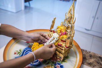 People are offering flowers placed on a BuddhaStatue