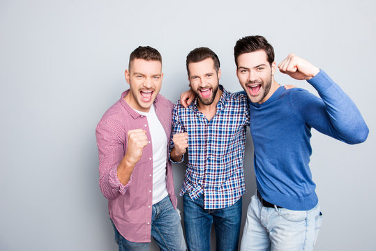  Portrait of cheerful, crazy, virile, harsh, funny guys in jeans, denim outfit with stubble and modern hairstyle yelling with wide open mouth, embracing, standing on grey background