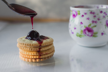 cookies with filling next with a glass of milk nicely at home, on top of the jam