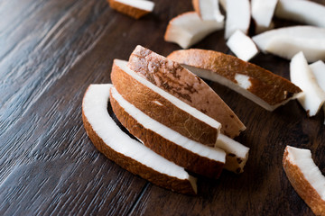 Slice of Fresh Coconut Pieces on Dark Wooden Surface.