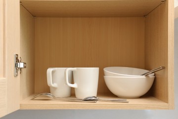 Kitchen cupboard with white cups. Live at home with my husband and wife. live together. Scandinavian style