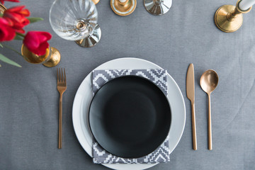 top view of black empty plate, napkin and old fashioned tarnished cutlery on tabletop