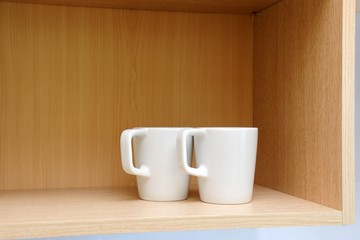 Fototapeta na wymiar Kitchen cupboard with white cups. Live at home with my husband and wife. live together. Scandinavian style