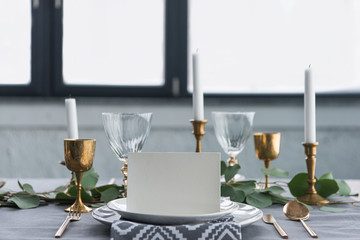 close up view of empty card on plates on tabletop with beautiful rustic setting for guests