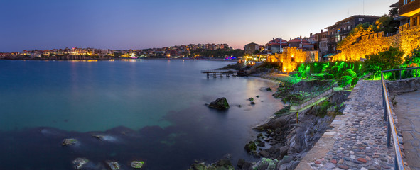 Seaside landscape, panorama, banner - view of the embankment with fortress wall during sunset in...