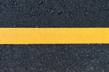 Fototapeta premium dirty orange line on surface of old asphalt in countryside