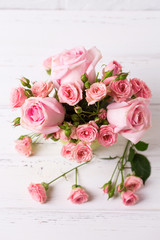 Pink roses flowers  on white wooden background.