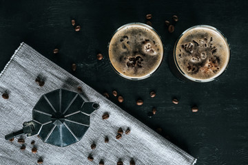 flat lay with coffee maker and glasses of cold brewed coffee on black tabletop