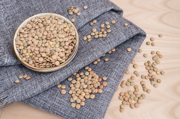 group of raw lentils on a kitchen towel and in a bowl