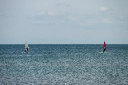 Windsurfing. Surfer exercising in calm sea or ocean.