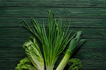 top view of green onion, leek and parsley on wooden table, healthy eating concept