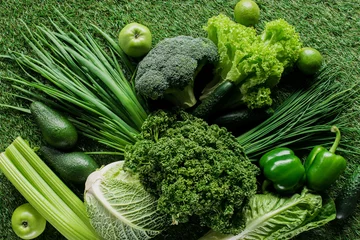 Fototapeten top view of uncooked tasty green vegetables on grass, healthy eating concept © LIGHTFIELD STUDIOS