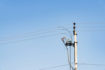 Electric pole with wires on the sky background