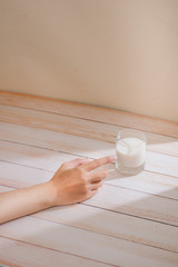 Fototapeta na wymiar Male hand touching a glass of organic milk