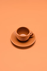 close up view of empty cup on saucer isolated on peach