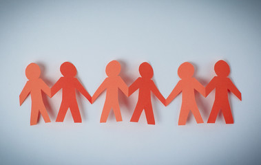 four paper men taking each other's hands