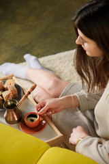 selective focus of young woman with cup of coffee on wooden tray at home