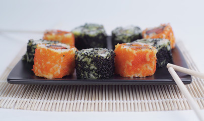 Sushi Set - different types of Maki sushi and chopsticks on a b