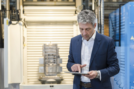 Businessman using tablet in production hall
