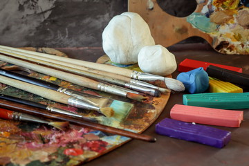 Palette with paints, colored clay and clay for modeling. School of Art. 
