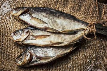close-up dried fish on a dark wooden background. Top view. Horizontal orientation.