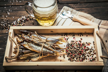 close-up dried fish, vintage glass of beer on a dark wooden background. Top view. Horizontal orientation.