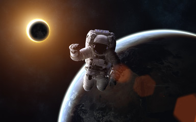 Astronaut. Solar eclipse. Moon and Earth. Image in 5K resolution for desktop wallpaper. Elements of...