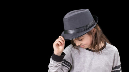  girl in cap with head tilted on black background