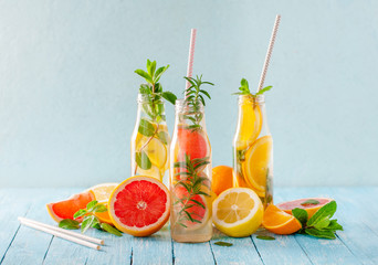 Variety of fruit infused detox water in small bottles. Set of refreshing summer drinks. Healthy...