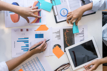 Hands of young businesspeople pointing at business graph report  on tablet in the office