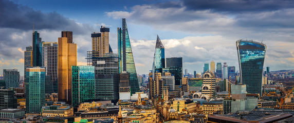 London, England - Panoramic skyline view of Bank and Canary Wharf, London's leading financial districts with famous skyscrapers and other landmarks at golden hour sunset with blue sky and clouds - obrazy, fototapety, plakaty