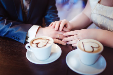Newlywed couple is sitting in a cafe for a cup of coffee. Wallpaper