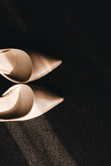 Elegant women's wedding shoes with rhinestones on a dark background, the fees of the bride, selective focus