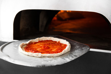 Italian pizza is cooked in a wood-fired oven. Close up