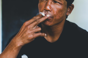 A man is smoking cigarette on black and white background